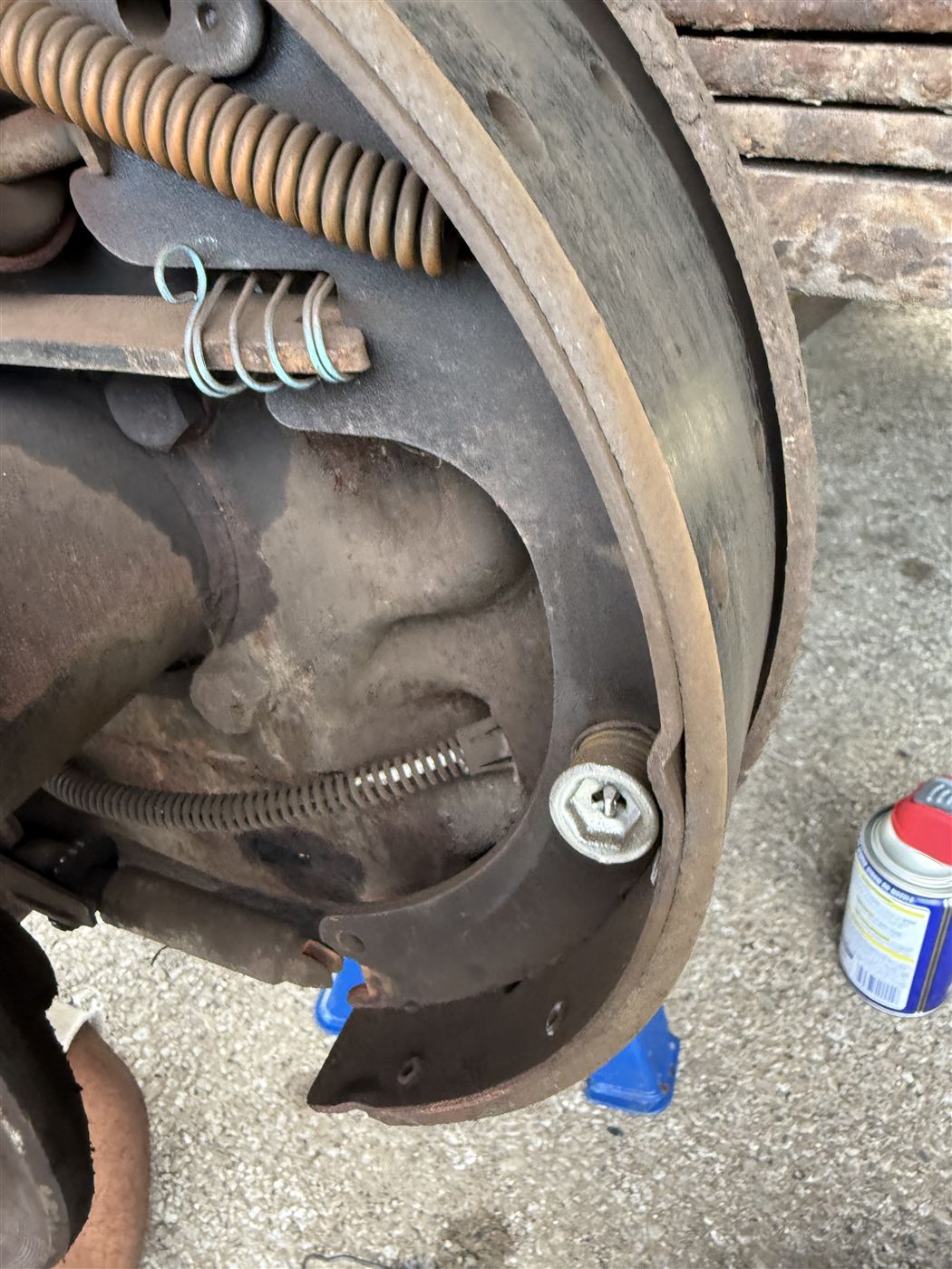 Rear drum brake service showing the brake shoes, springs, and hardware exposed
