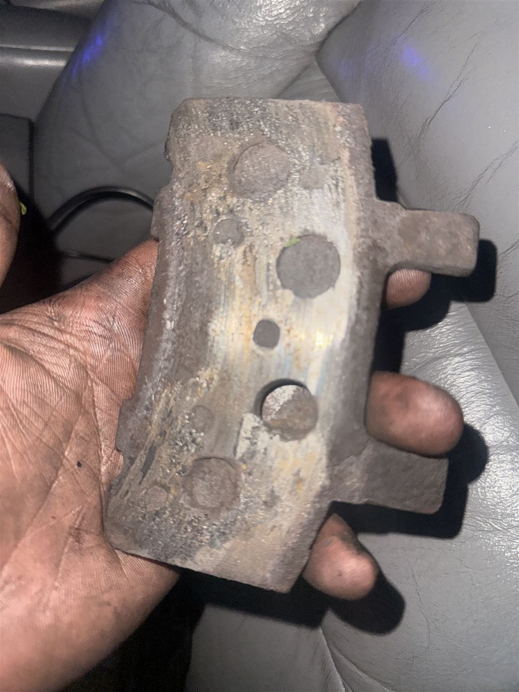 Worn brake pad held up for inspection before replacement