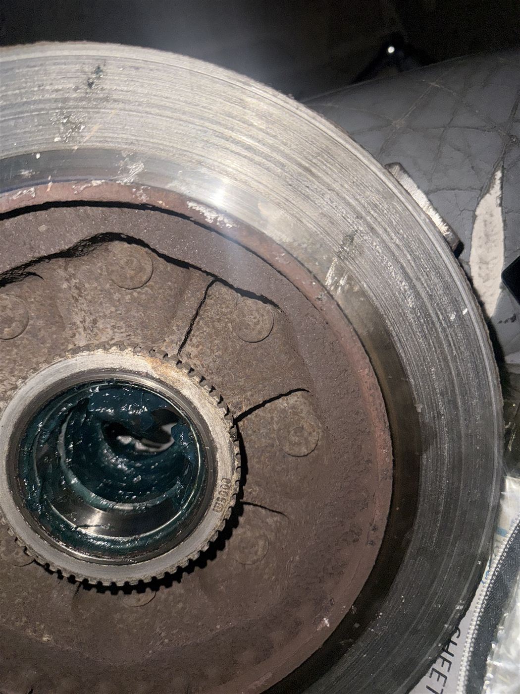 Close-up of a worn, cracked brake rotor removed during a brake service